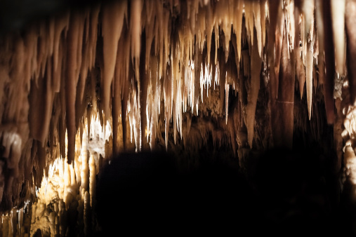 Stalactites hang from the roof of a limestone cave. ©Getty Images