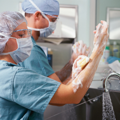 Surgeons follow Lister's teaching. They scrub up using antiseptics and wear gloves before starting to operate. © Getty Images