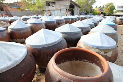 Terracotta barrels of fermenting fish sauce in Vietnam . Photo©Getty