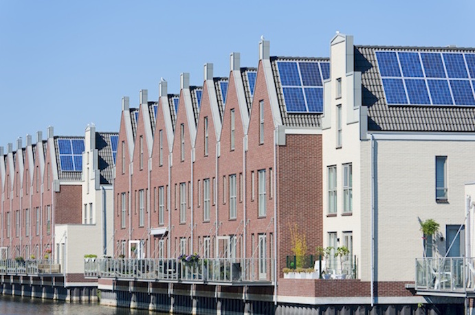 Solar panels mounted on the roof heat water. Windows and glass doors let in light and the sun's heat. Getty Images.