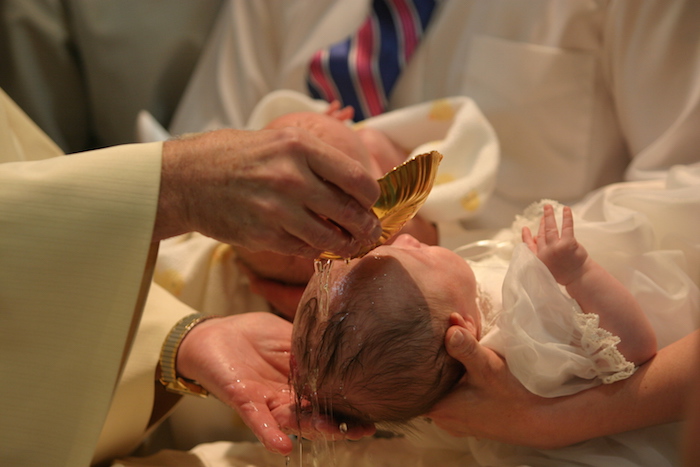 Baptism of a baby: holy water is dripped onto the baby's head as special prayers are said to welcome the baby toChristianity. ©Getty Images