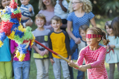 When the pinata breaks, sweets pour out and all the children collect them. ©Getty