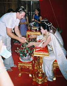 A wedding guest pours water over the bride and groom's hands for luck