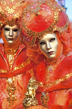 Some people dressed in fancy costumes and wearing masks in Venice at Carnevale