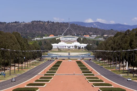 Parliament House, Canberra. The white building in the foreground is the first Parliament House built in Canberra in 1927 © iStock