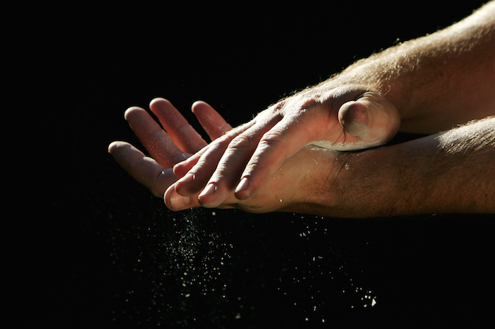 Weightlifters rub their hands with chalk to grip the bar without slipping. ©Getty