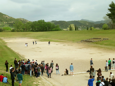 Tourists visit the stadium in Olympia. Notice that is was a rectangle shape, unlike the circular stadium used at the modern Olympics. © iStock