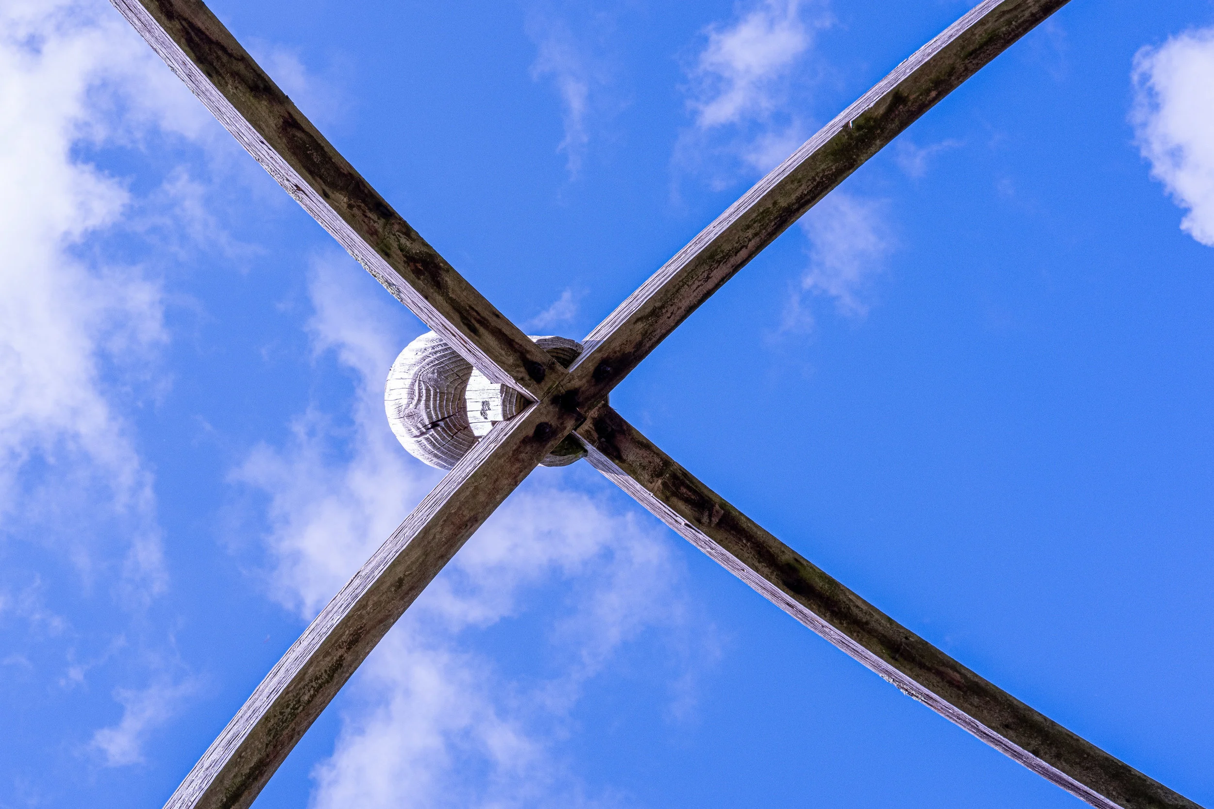 The wooden structure on the columns creating a pergola was capped by gently curving beams leading to the large finial in the centre.