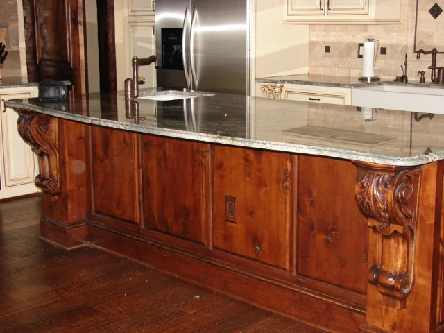  Knotty alder island with a raised panel back and large carved corbels. 