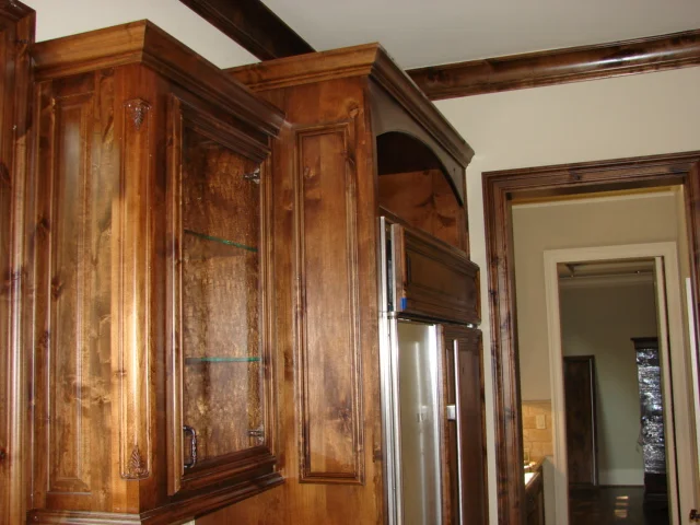  Knotty alder cabinets with custom mitered doors and carved filigree corner moulding. 