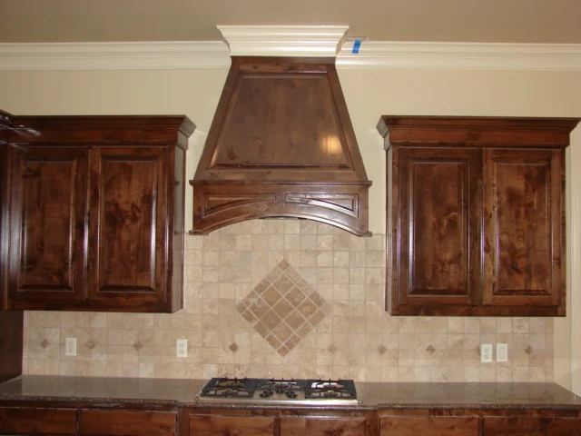  Knotty alder cabinets with square raised panel doors on a standard 1/2" overlay. Custom hood cover with an arched raised panel. 