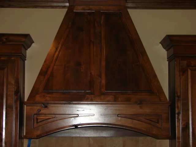  Knotty alder custom hood cover with an arched raised panel. 