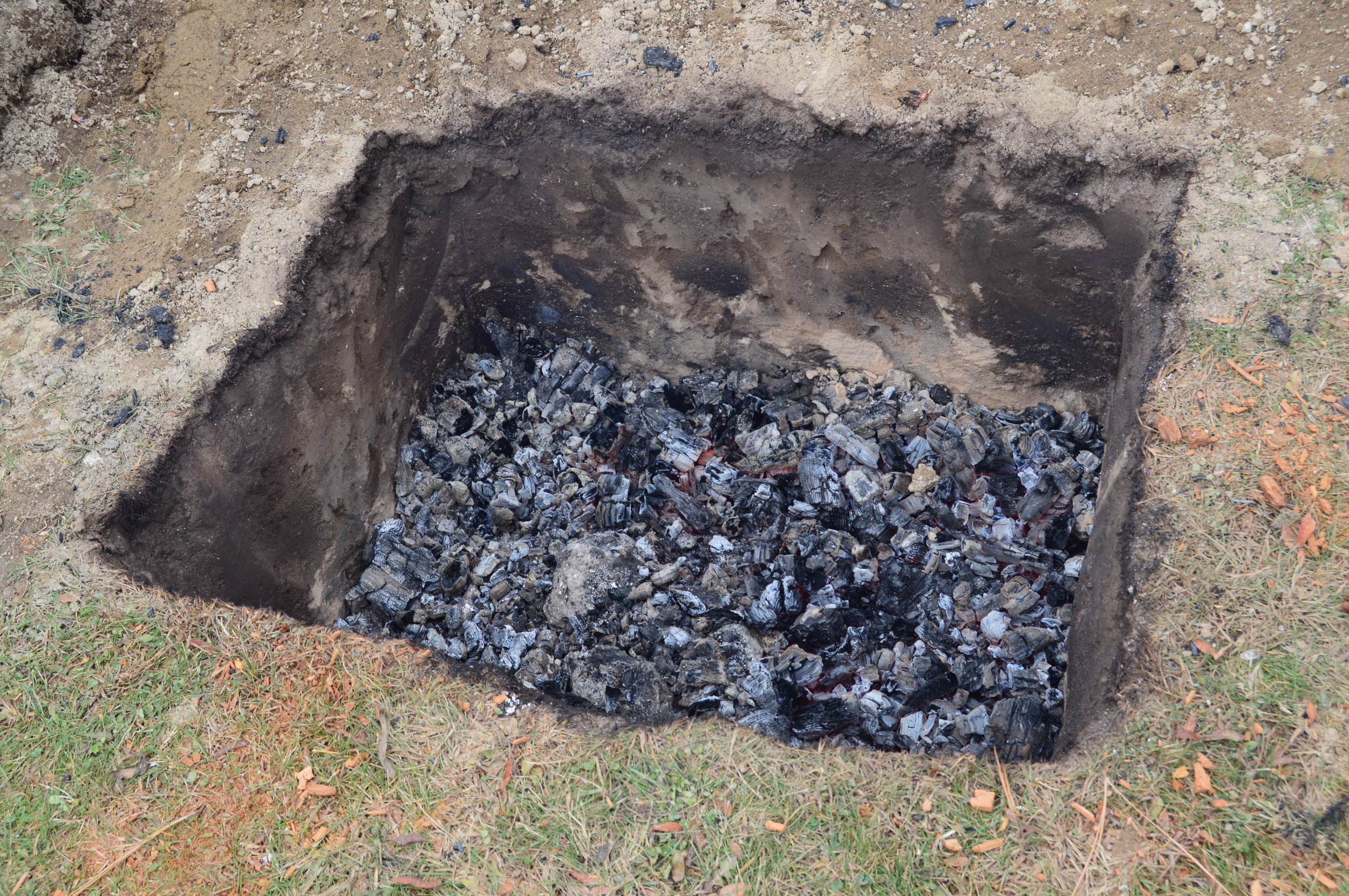 Image of a pit with a coal bed of embers 