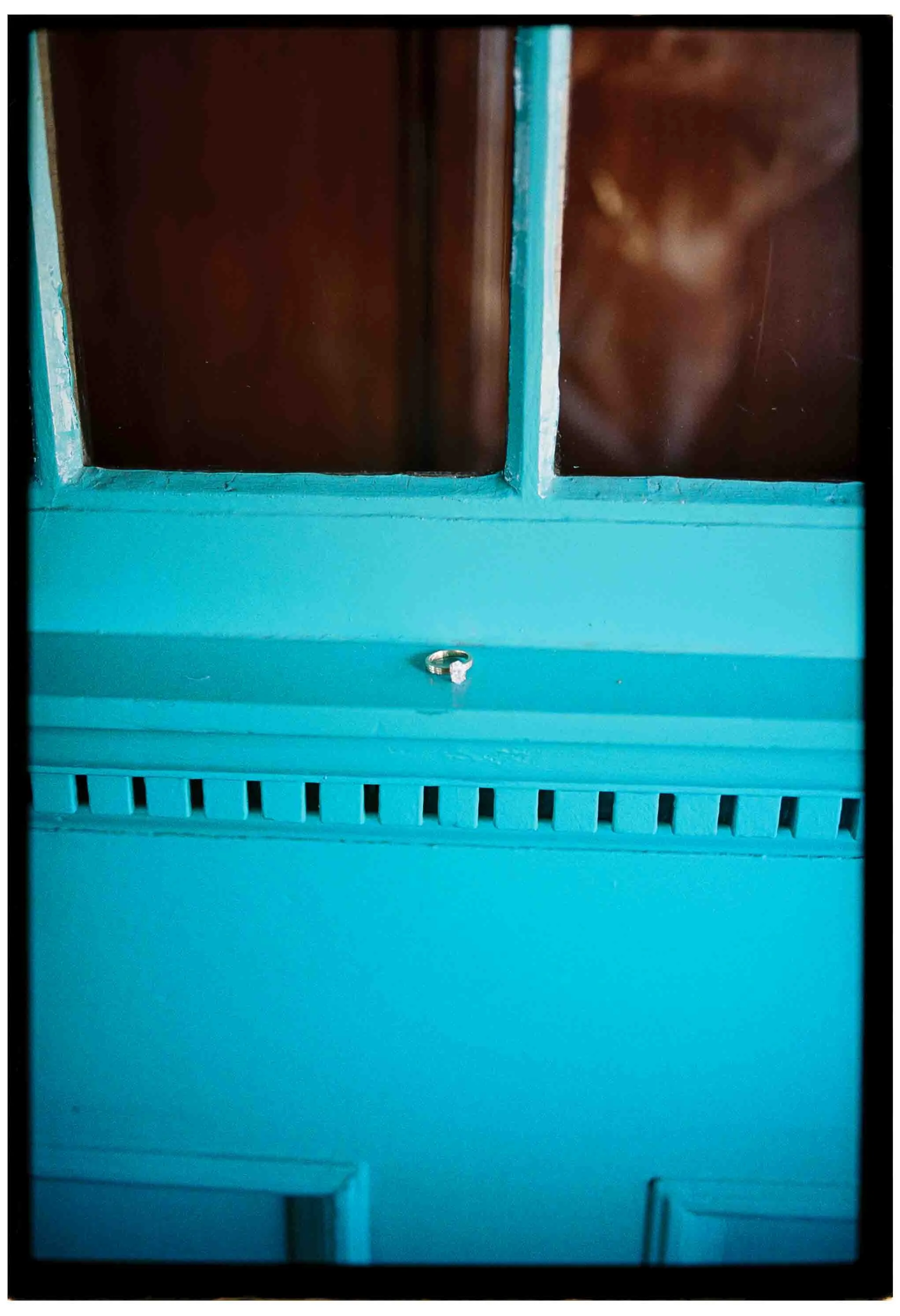 emerald cut diamond engagement ring on a turquoise window ledge