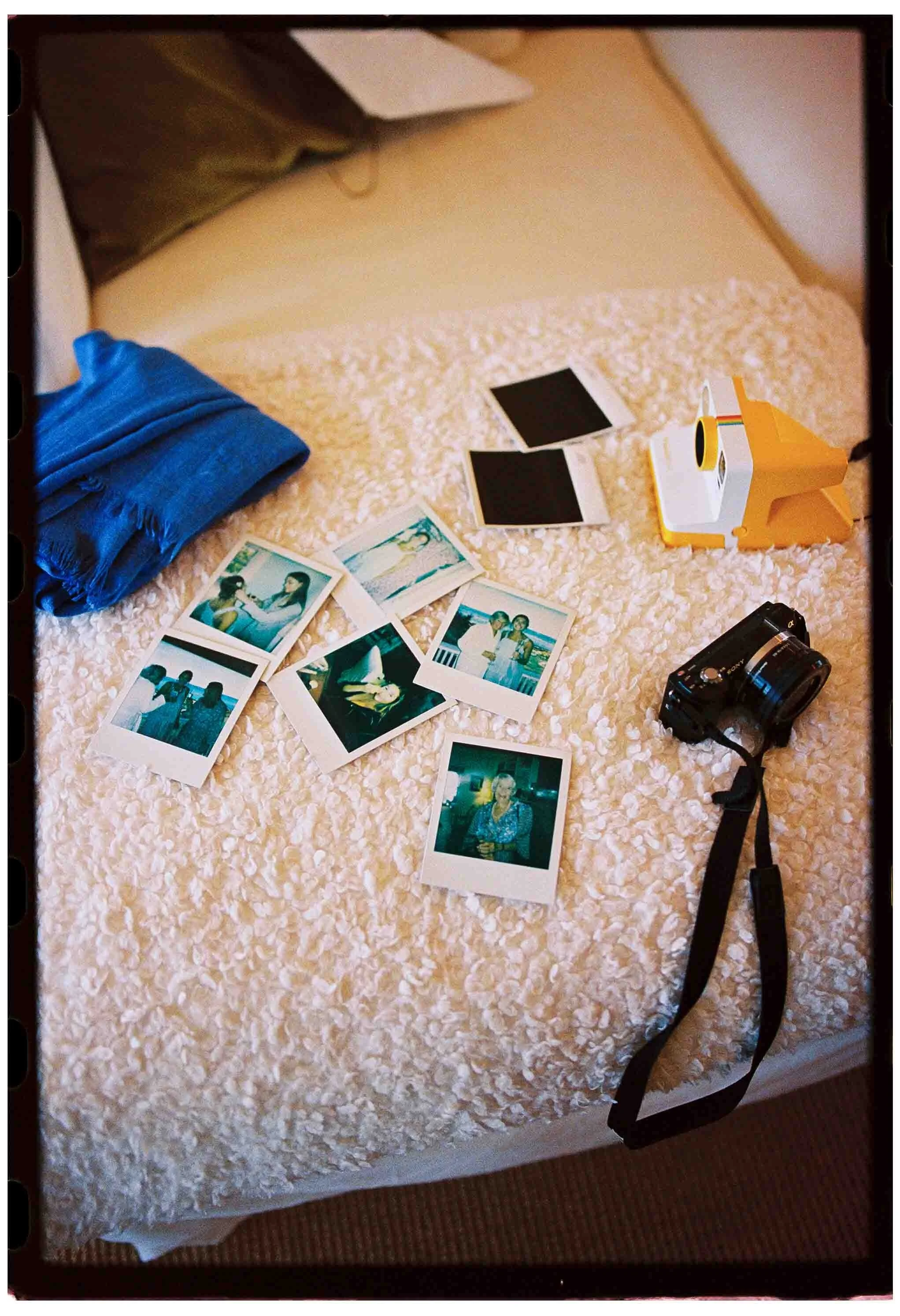 Polaroids and a camera laid out on a couch
