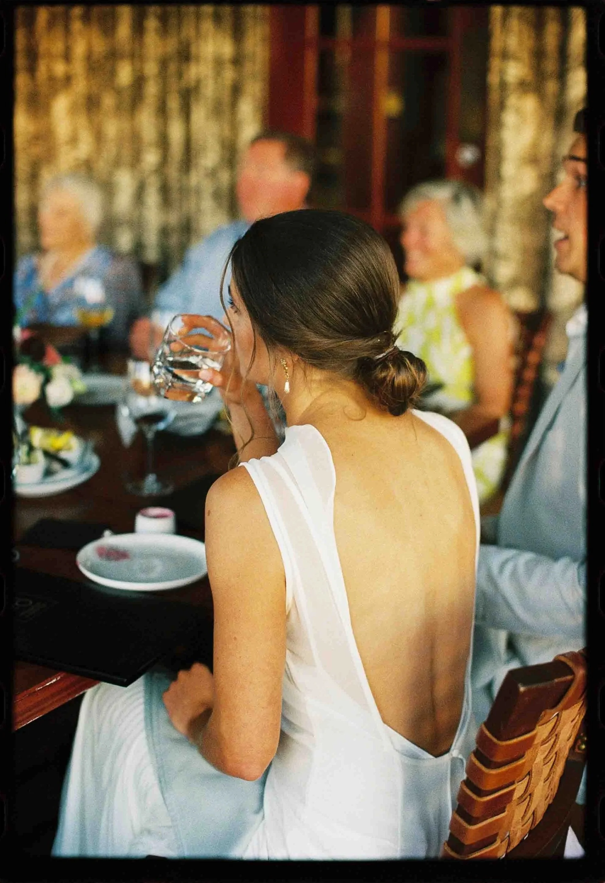 A newlywed in a wedding dress sitting at their reception