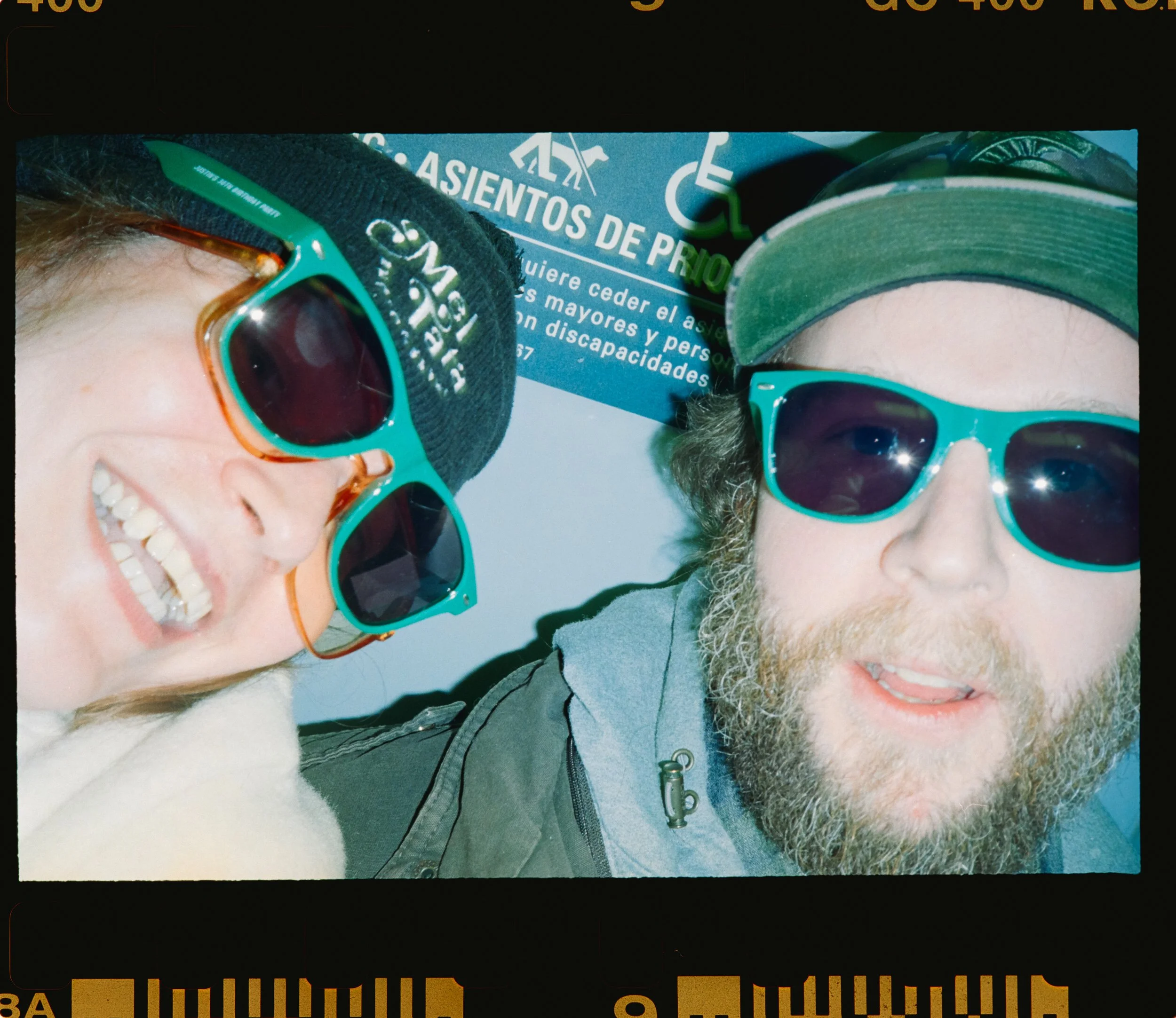 Two people smiling in matching sunglasses