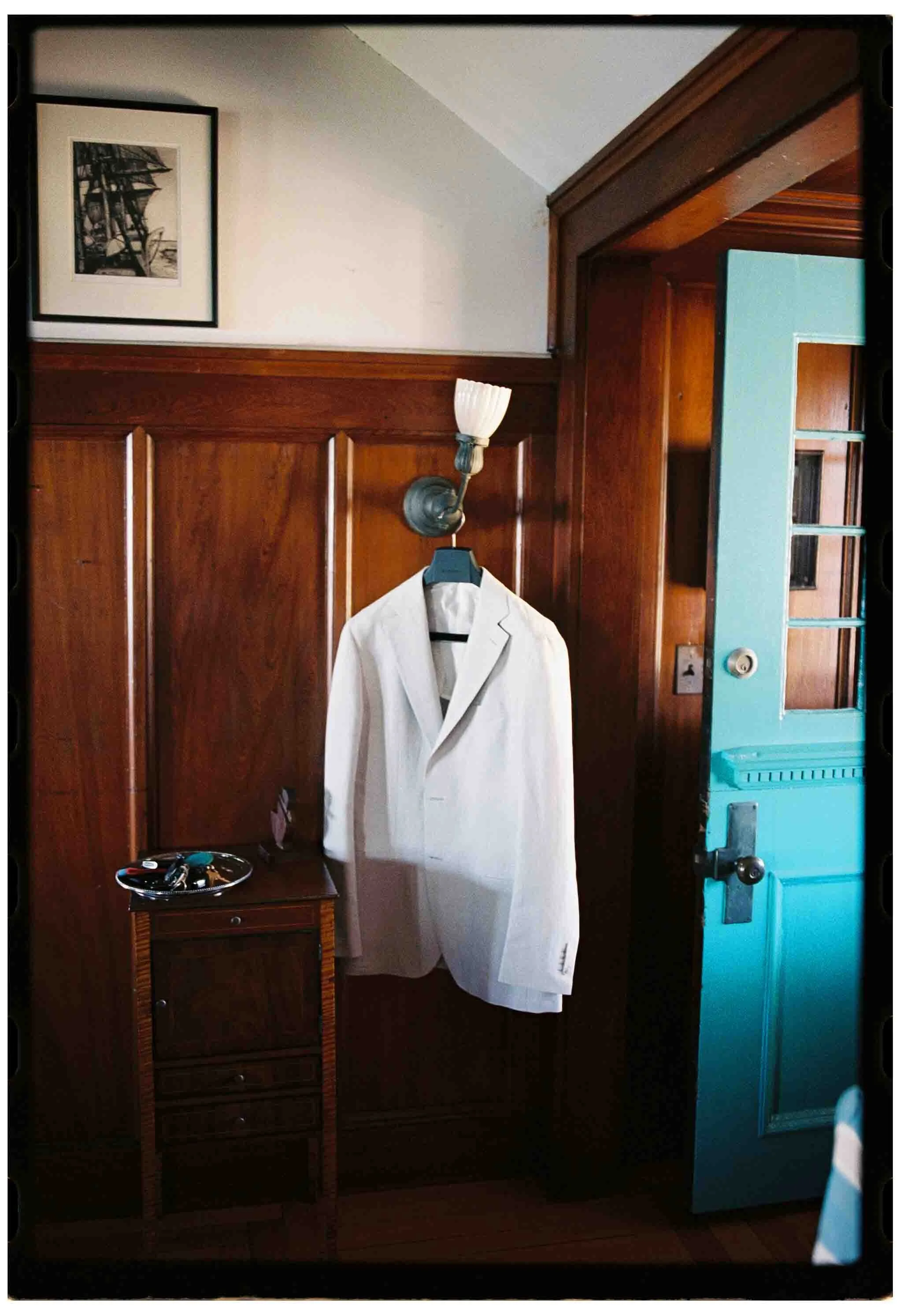 grooms suit jacked hangs from lamp in ancestral gloucester home with shiplap walls