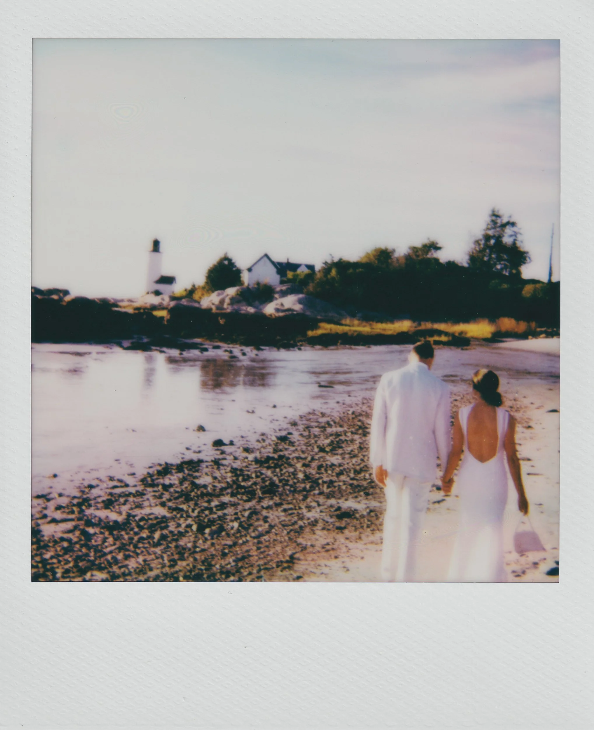 newlyweds holding hands and walking along the beach
