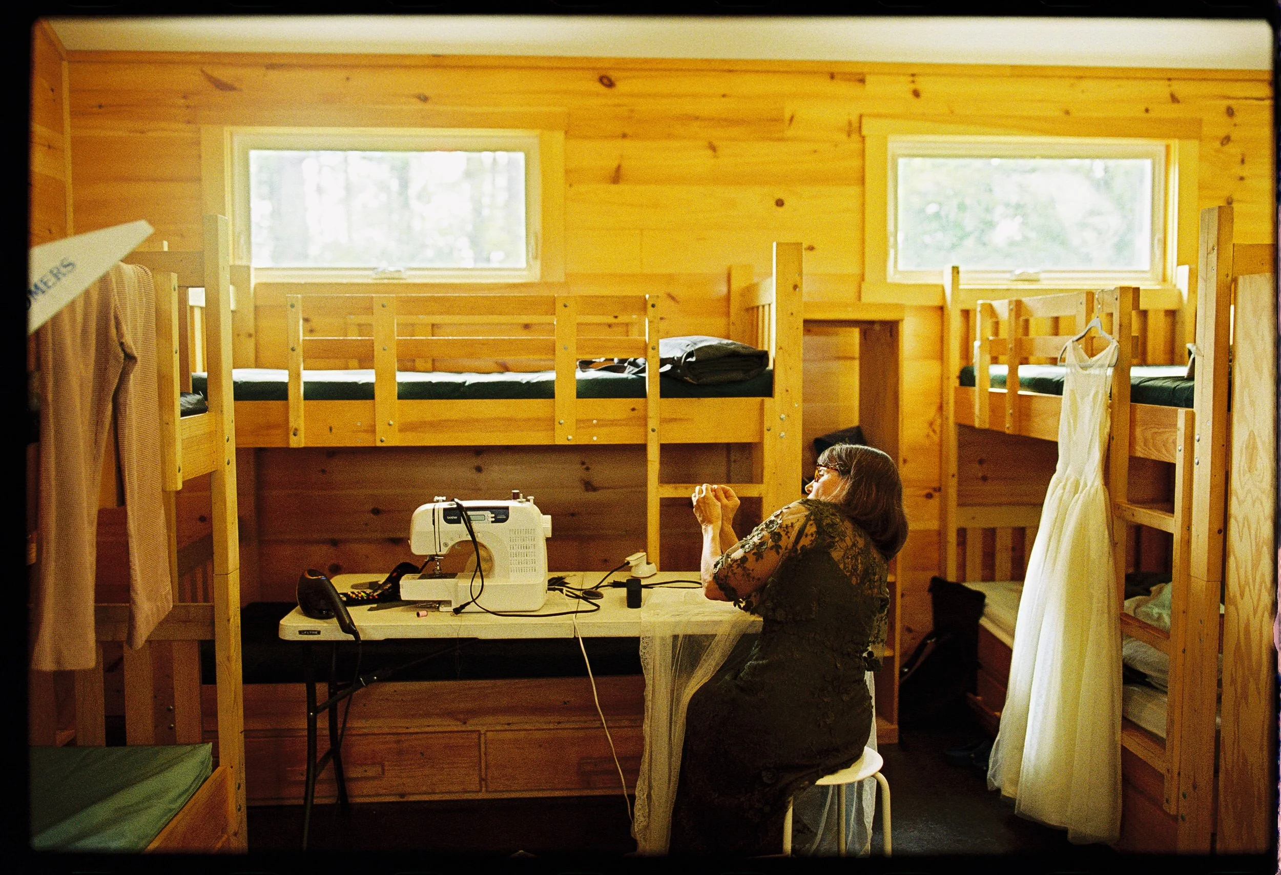 A person in a wood cabin sewing