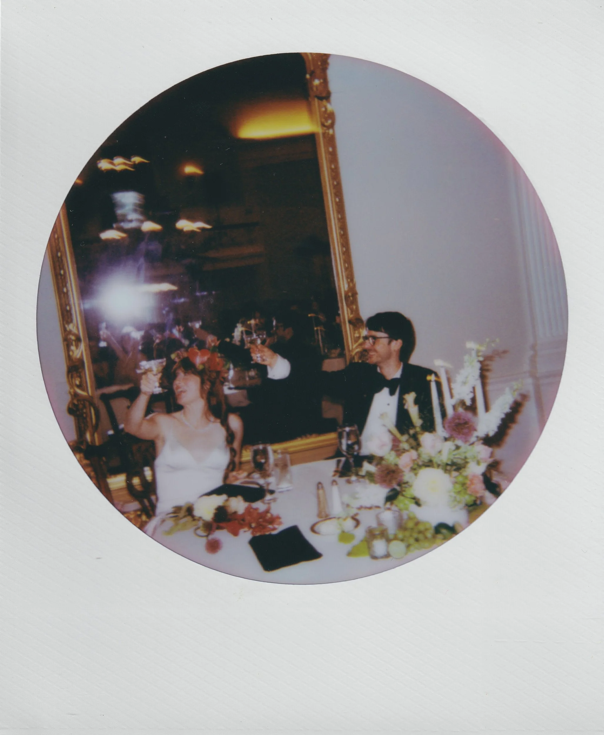 Newlyweds at their reception holding up glasses in a toast