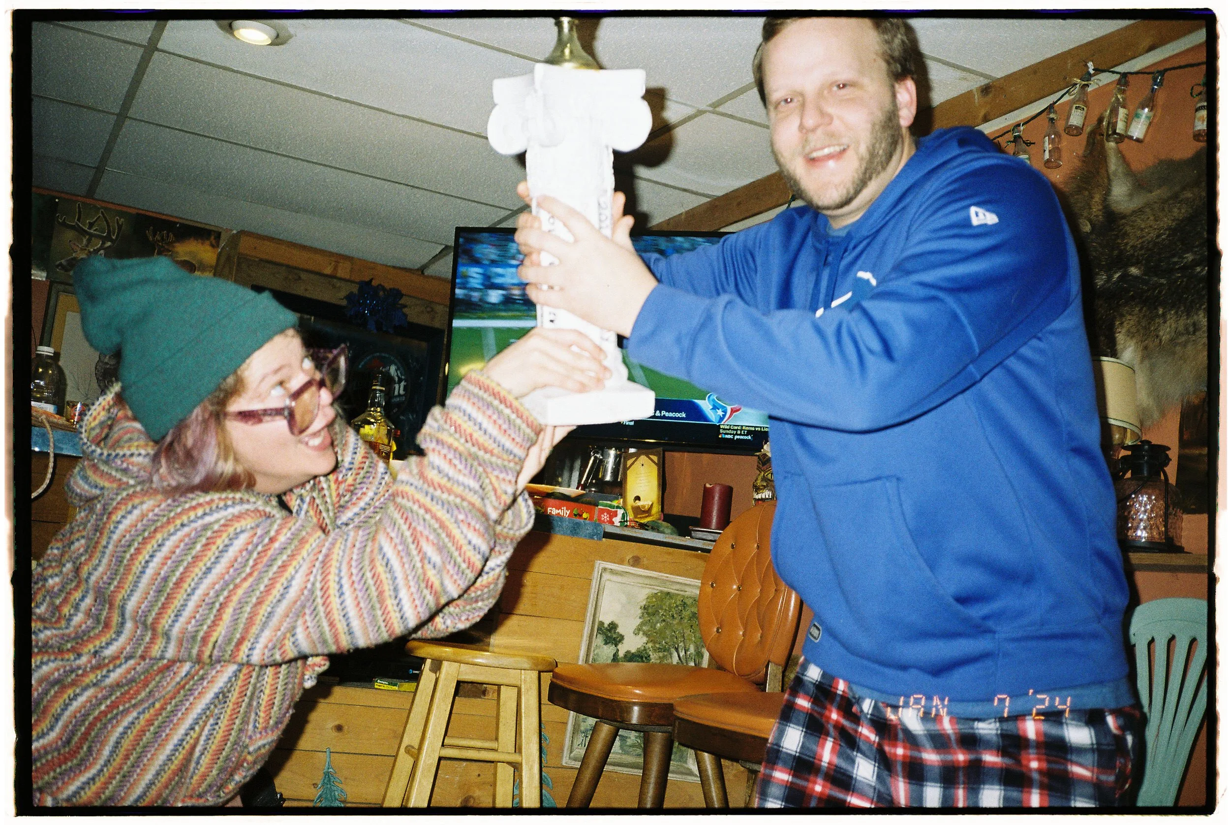 Two people holding up a small trophy