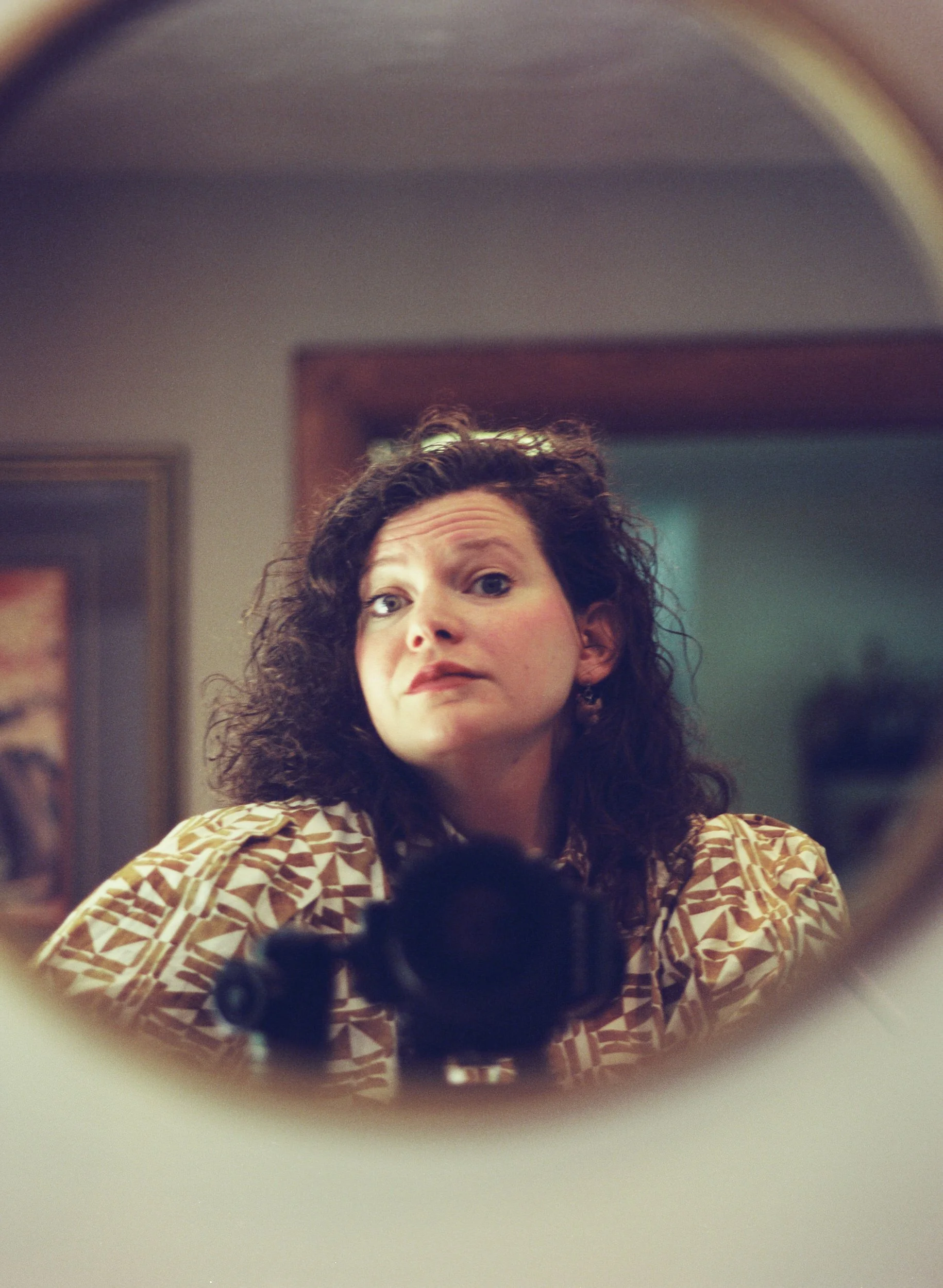 Mel taking a self in a round mirror