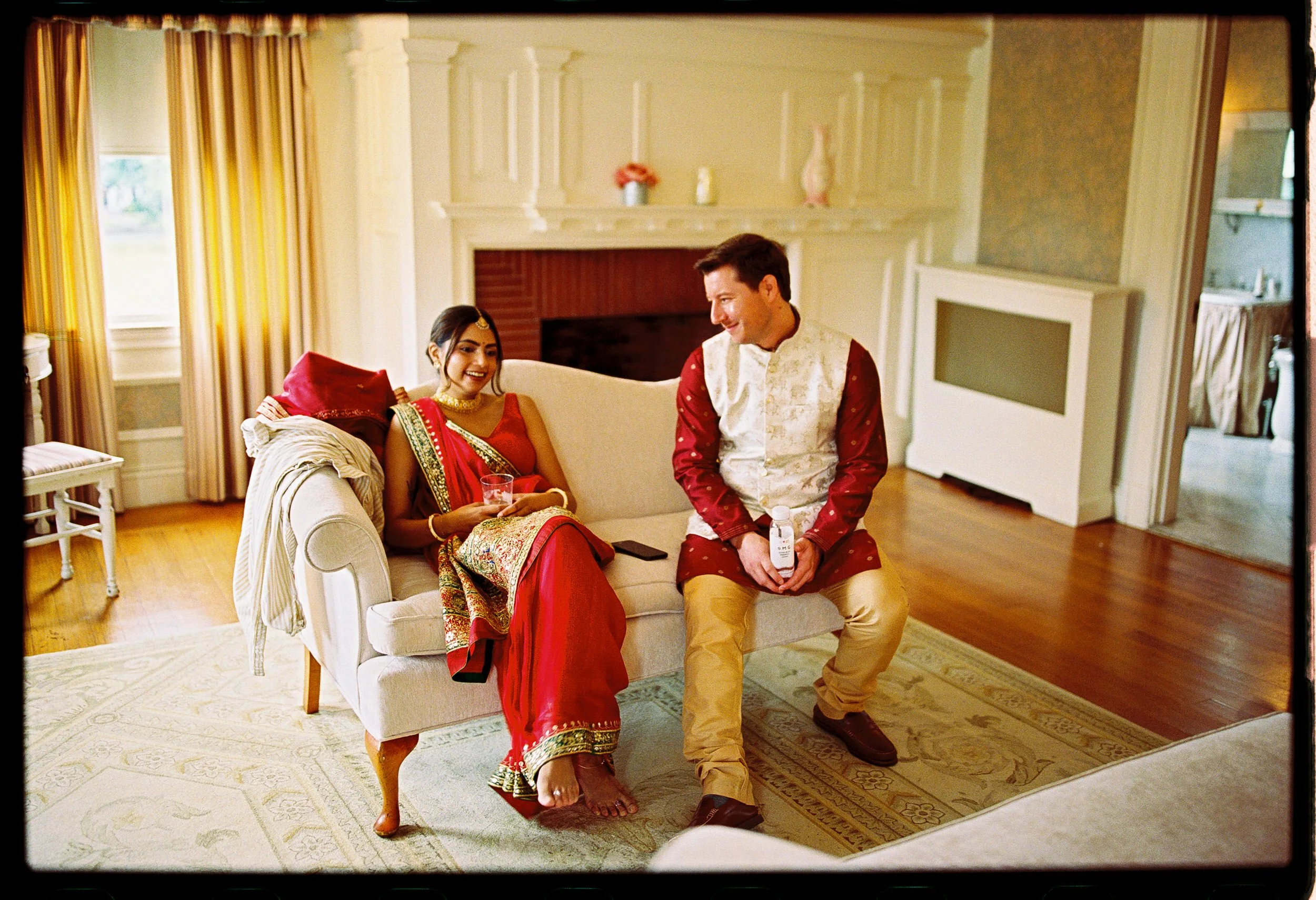 A newlywed couple sitting on a small couch together