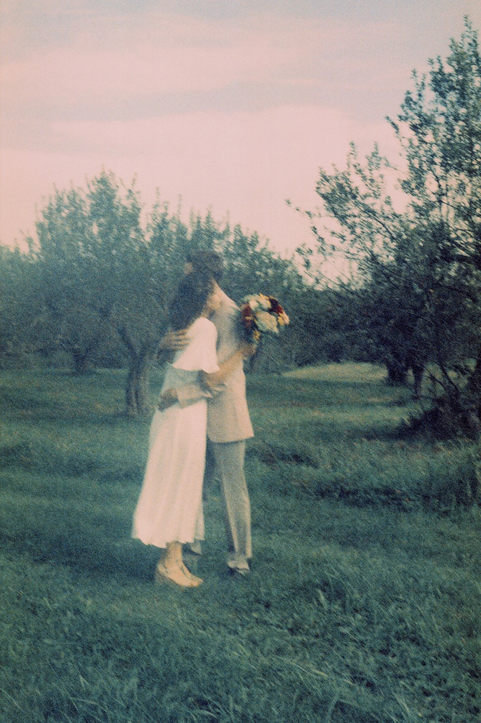 A newlywed couple hugging in a field