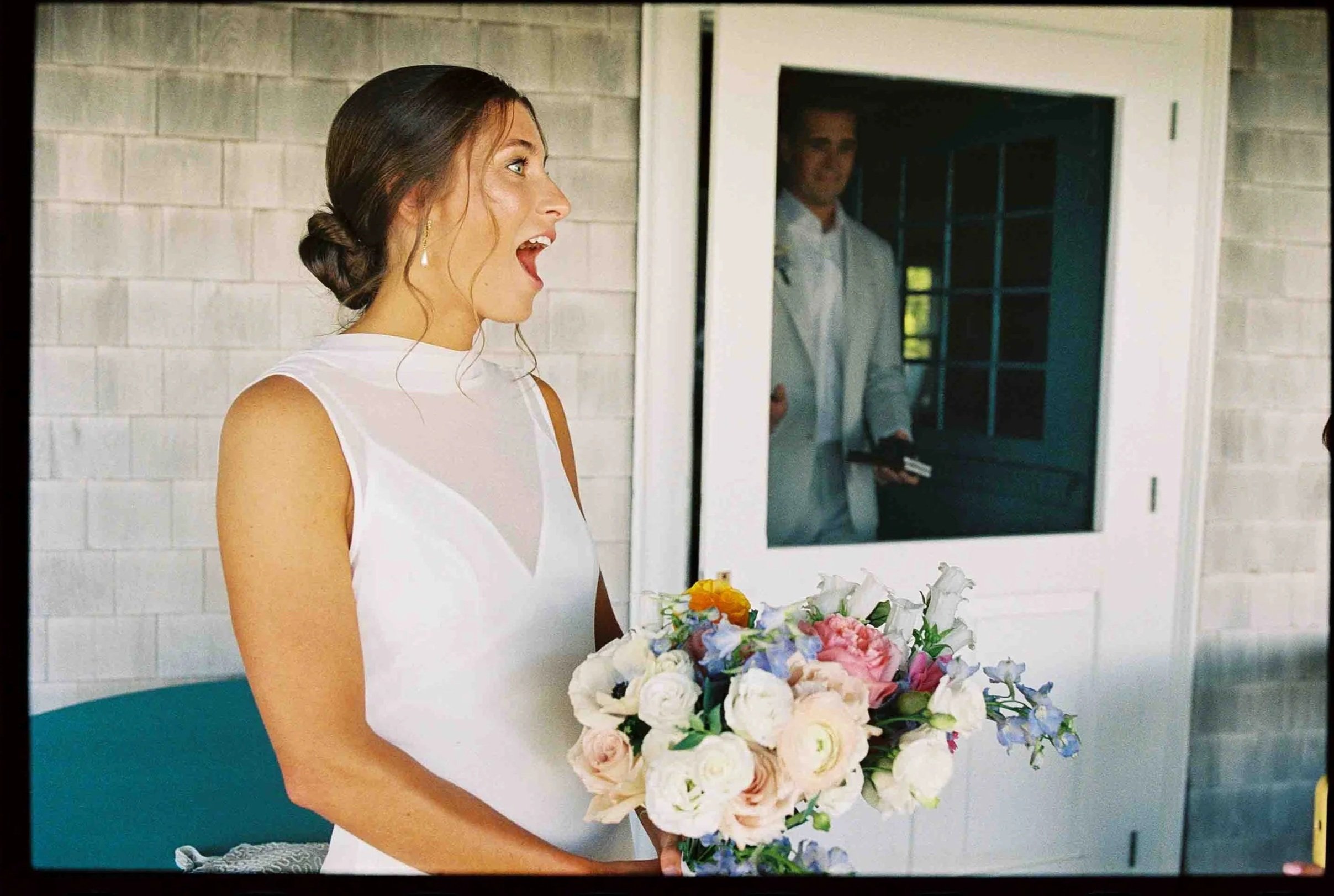 A newlywed holding a bouquet with a surprised look on their face