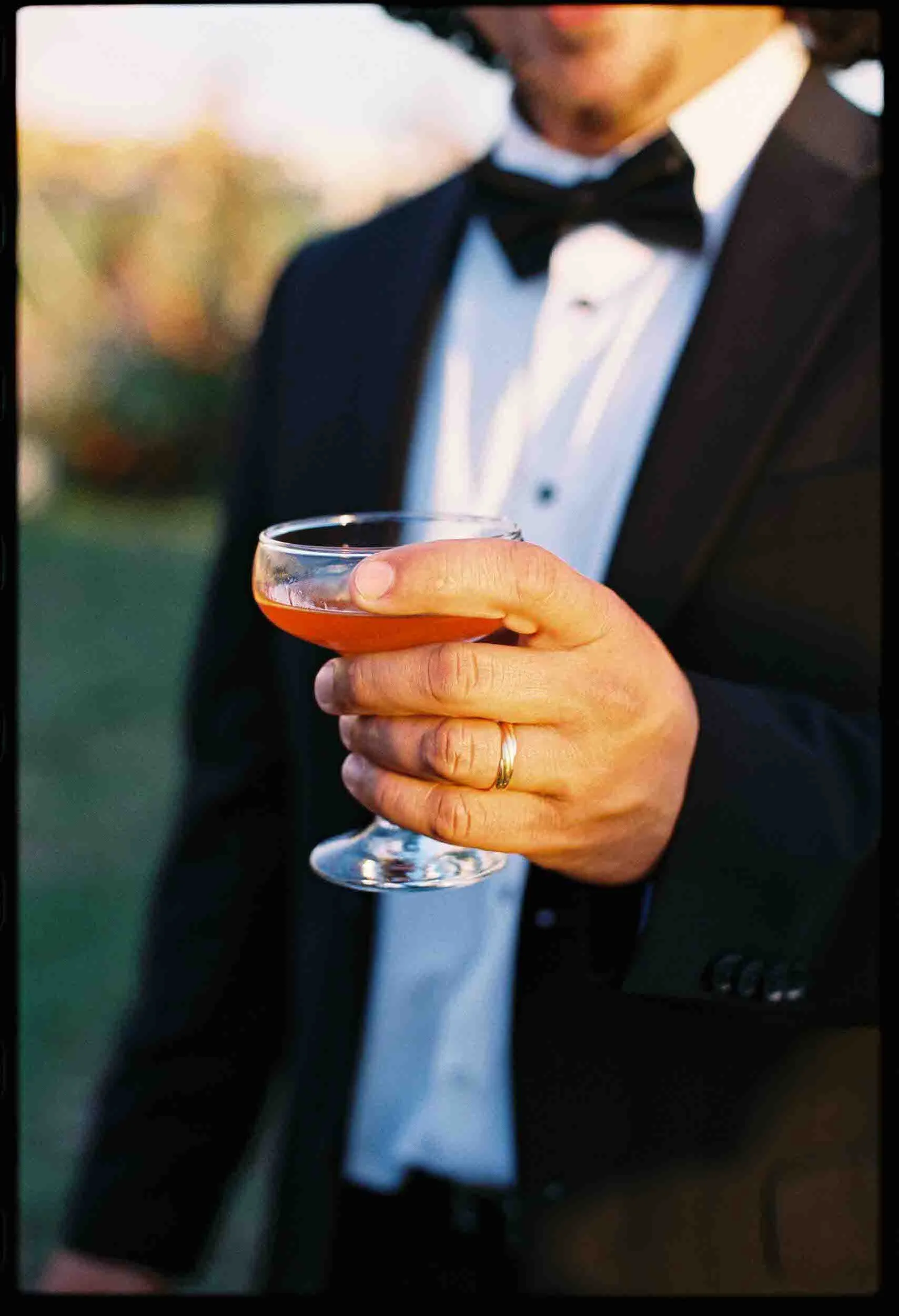 A close up of someone holding up a cocktail glass in a toast