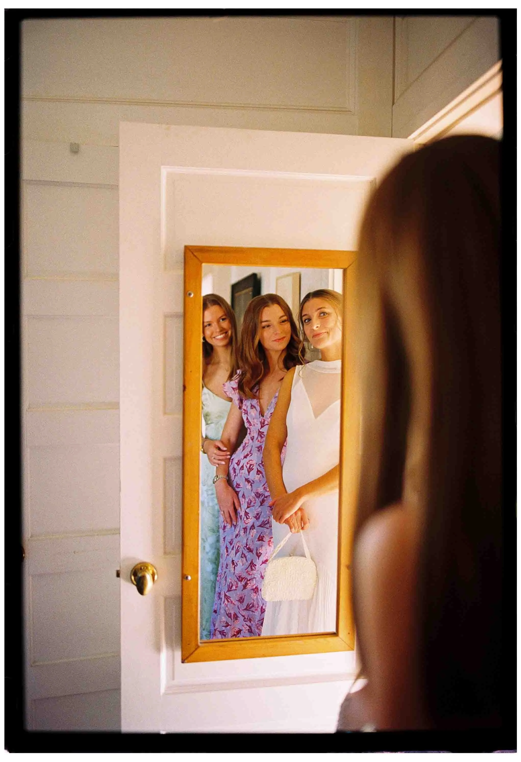 bride and sisters admire themselves in mirror before ceremony