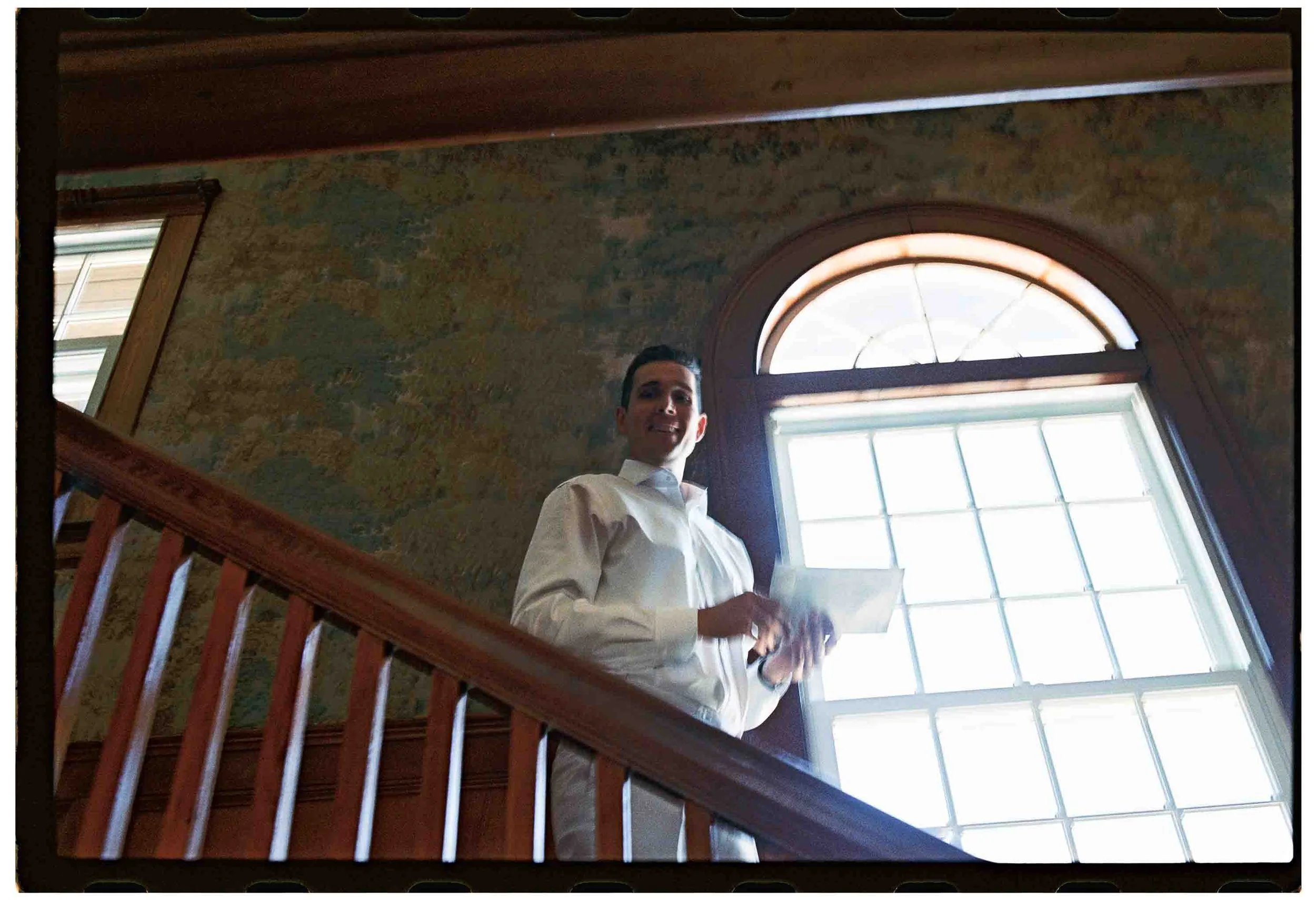 Groom decends stairs on his wedding day in Gloucester MA