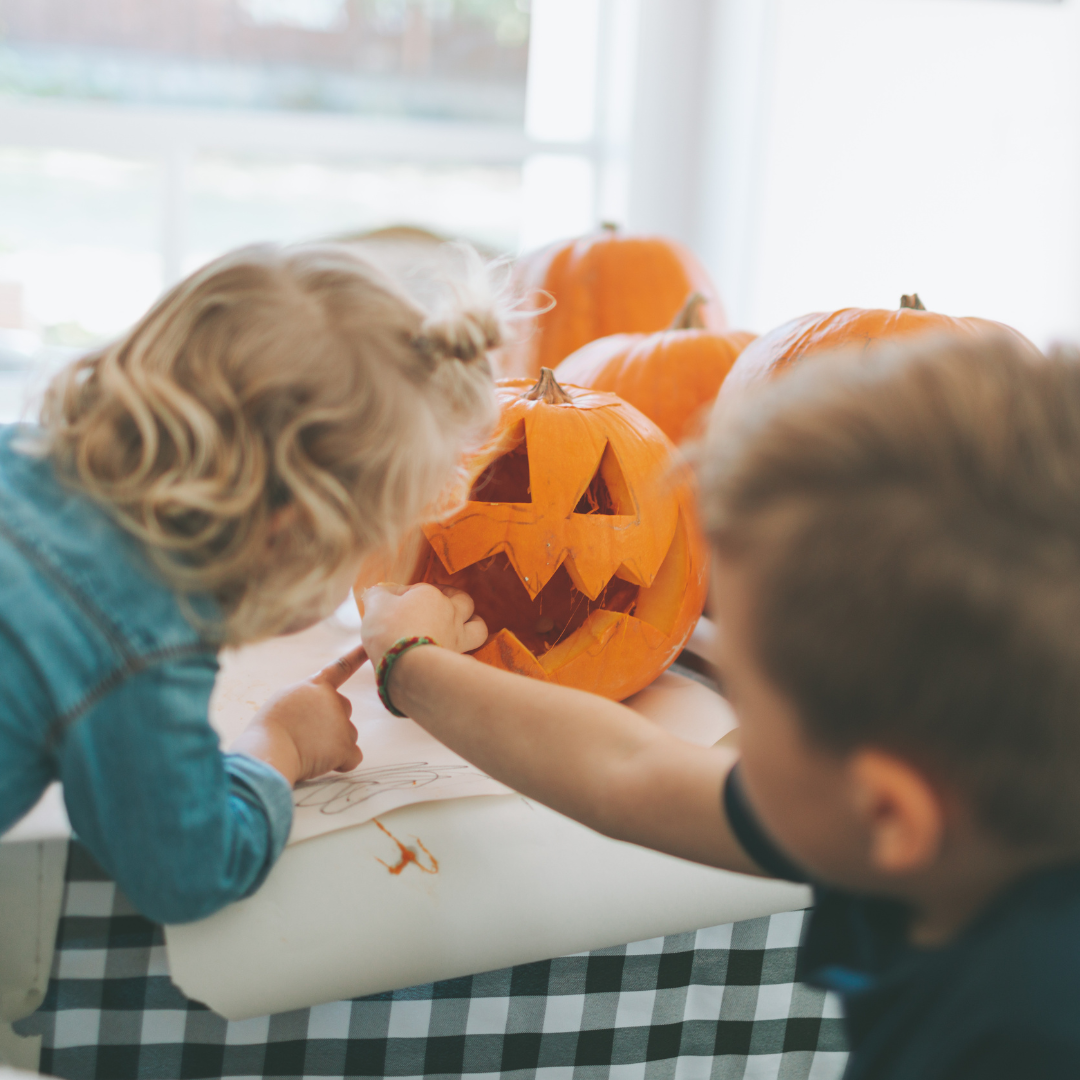 A child carving a glowing Halloween pumpkin on the farm