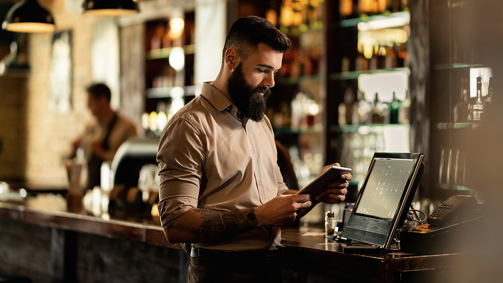 A bartender puts an order in at a point-of-sales system at the restaurant’s bar.