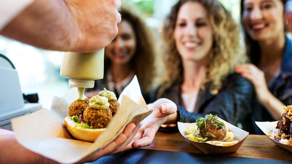 A food truck cook serving three woman