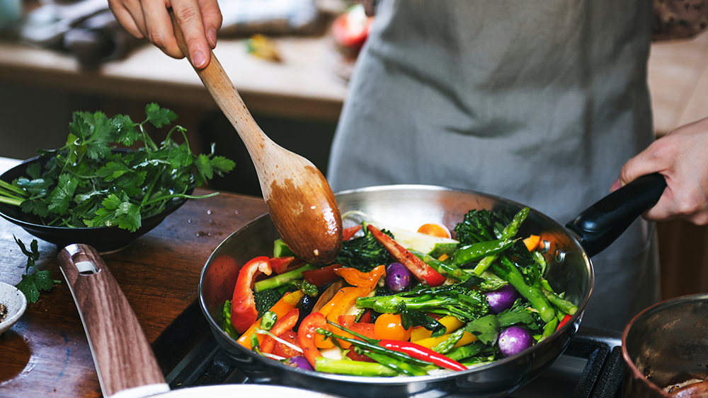 A restaurant chef cooking stir fried veggies