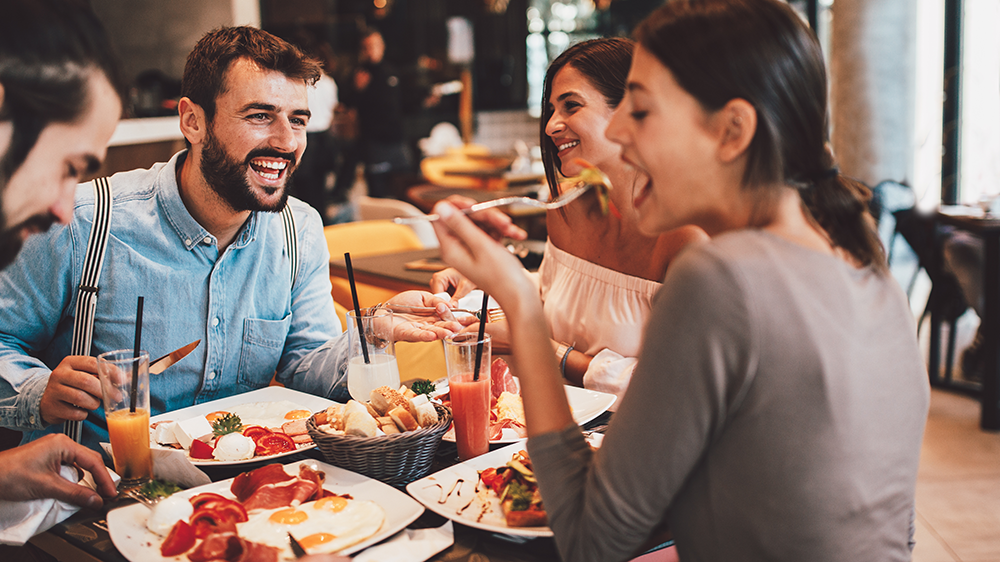 Smiling and laughing restaurant guests eating