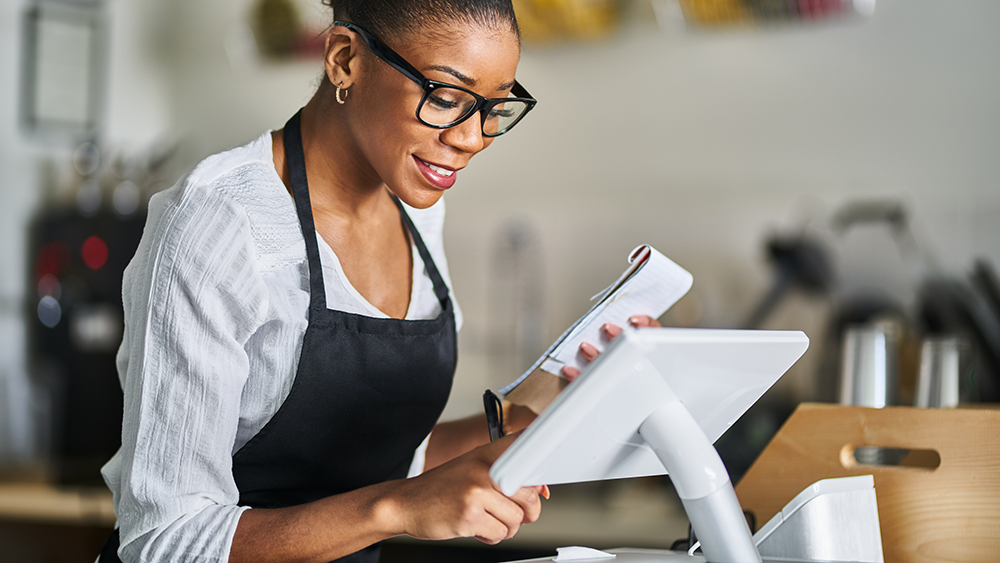 A restaurant employee working at a point-of-sales system