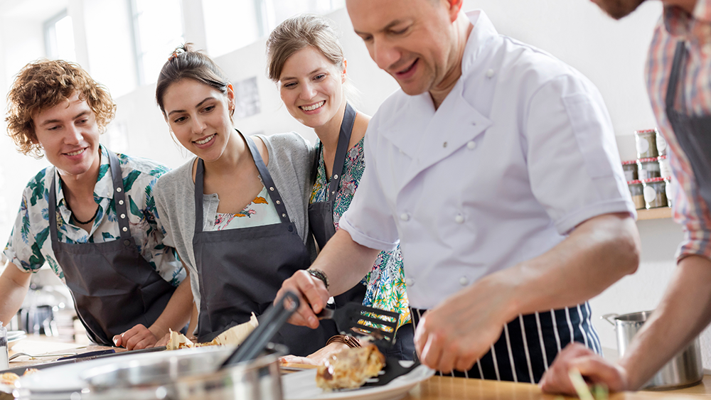 A restaurant chef leads a cooking class with local community members