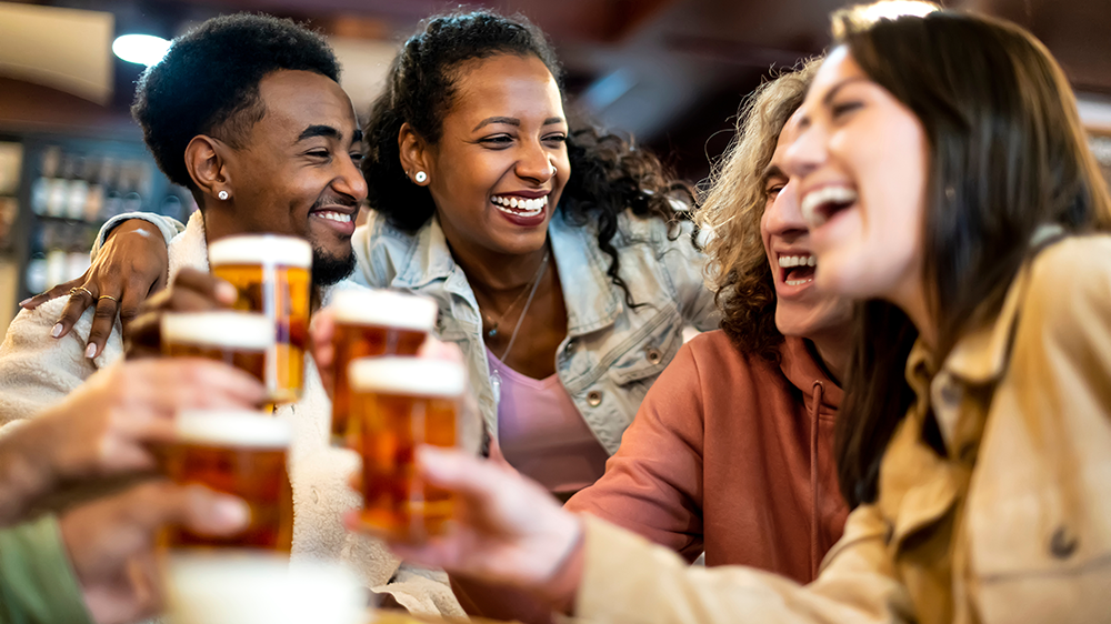 Bunch of friends laughing and drinking beer at a local restaurant