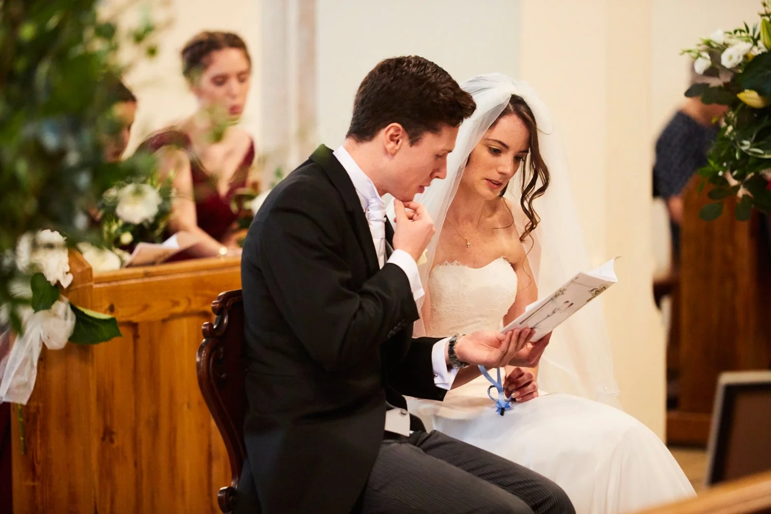 A bride and groom reading vows during a wedding ceremony inside a church.