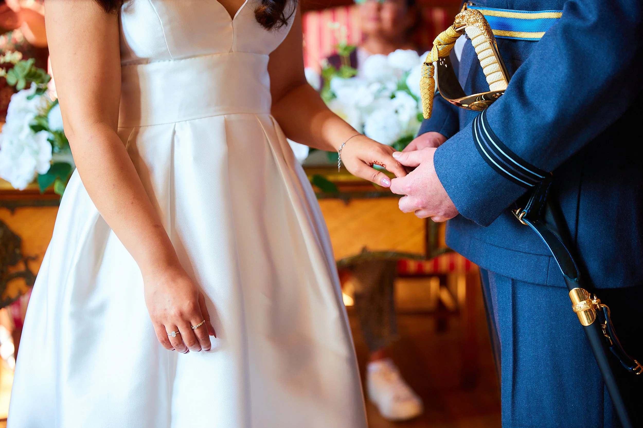 Close-up of a bride and groom during a wedding ceremony, holding hands.