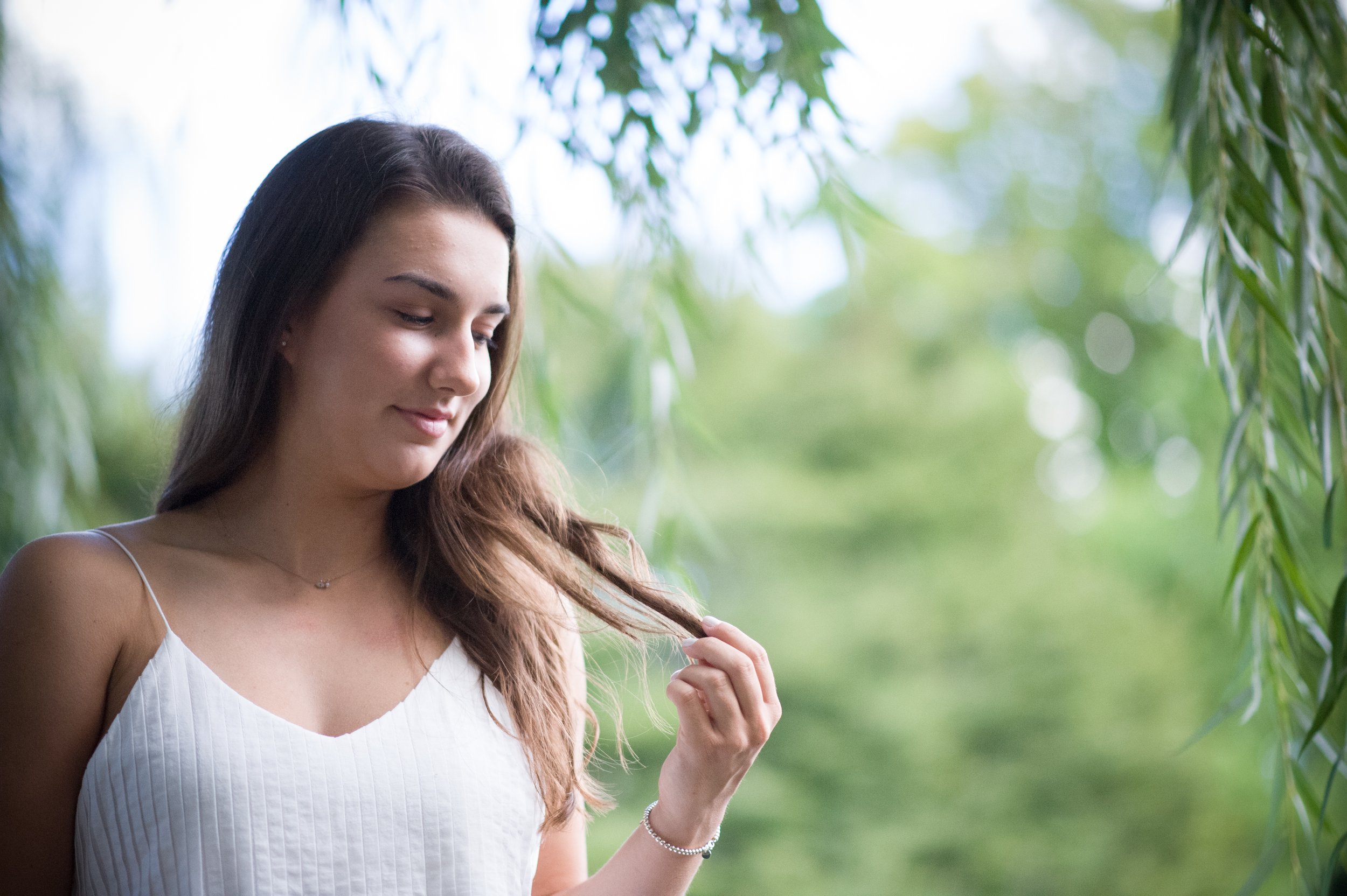     A beautiful senior portrait of a young girl captured outside at the stunning Chicago Botanic Gardens during the summer on a bright, sunny day. The vibrant greenery and colorful flowers create a picturesque backdrop, showcasing not only her joy bu