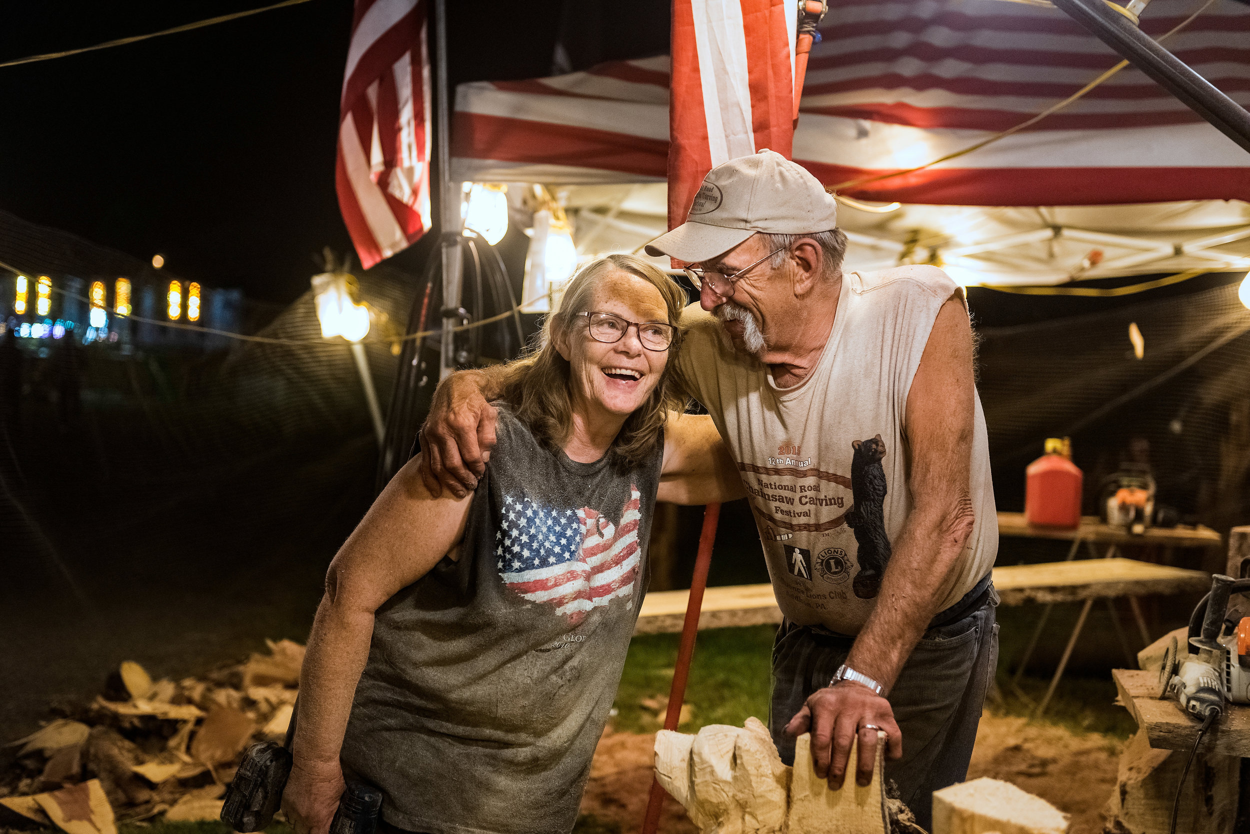 Sue and Rick Cox, of R & S Chainsaw Carving, share a laugh together as they take a momentary break from carving Monday evening, Sept. 4, 2017 at the Iredell County Fair in Statesville, N.C. They have been carving 17 of the 44 years they have been married. Every year, the couple travels to over ten states for five months to set up at chainsaw competitions, craft shows and fairs. This might be their last year of traveling as "it's getting very hard," because "that's about all we do - is work," Rick said.