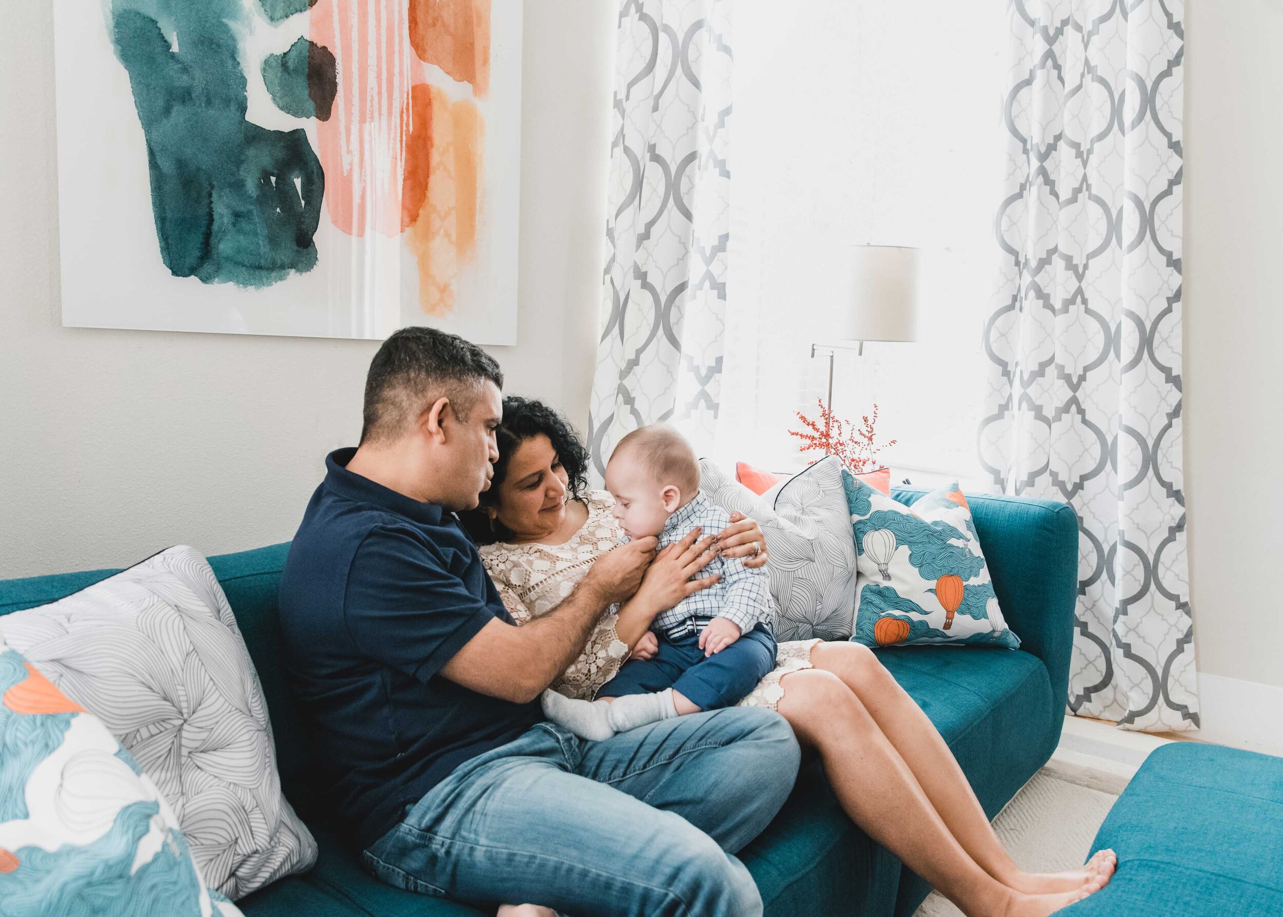 Mom, dad, baby on living room couch