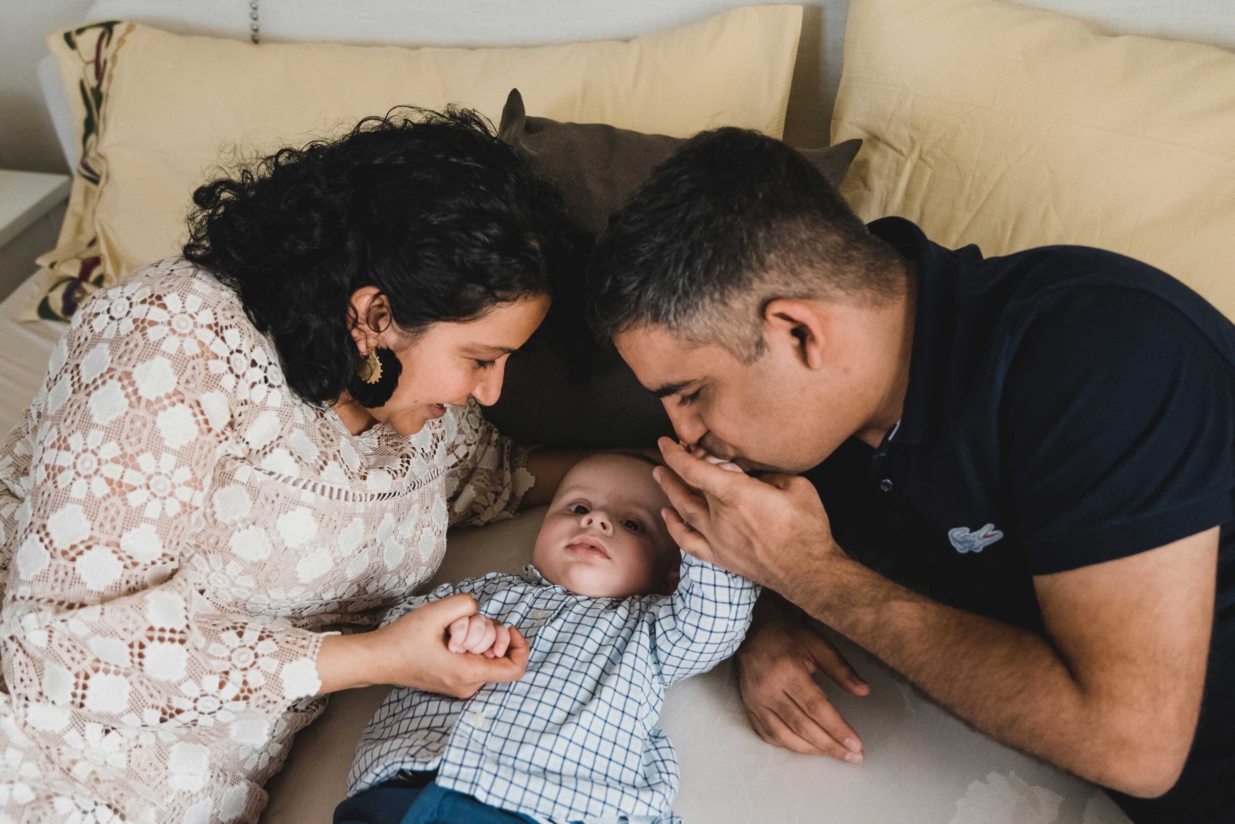 Mom, dad, baby cuddling in bed