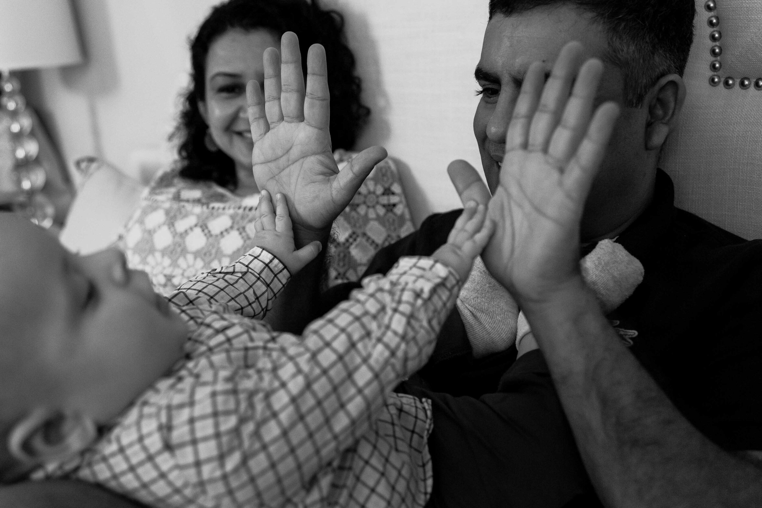 Baby and daddy playing patty cake, black and white family photograph