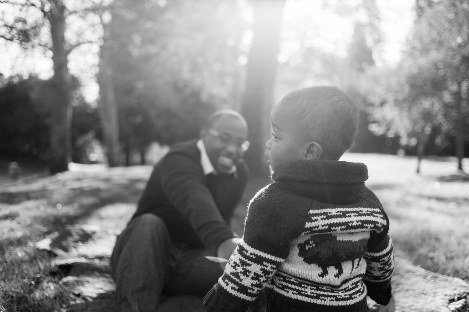 Over the shoulder photo of young boy and father in park