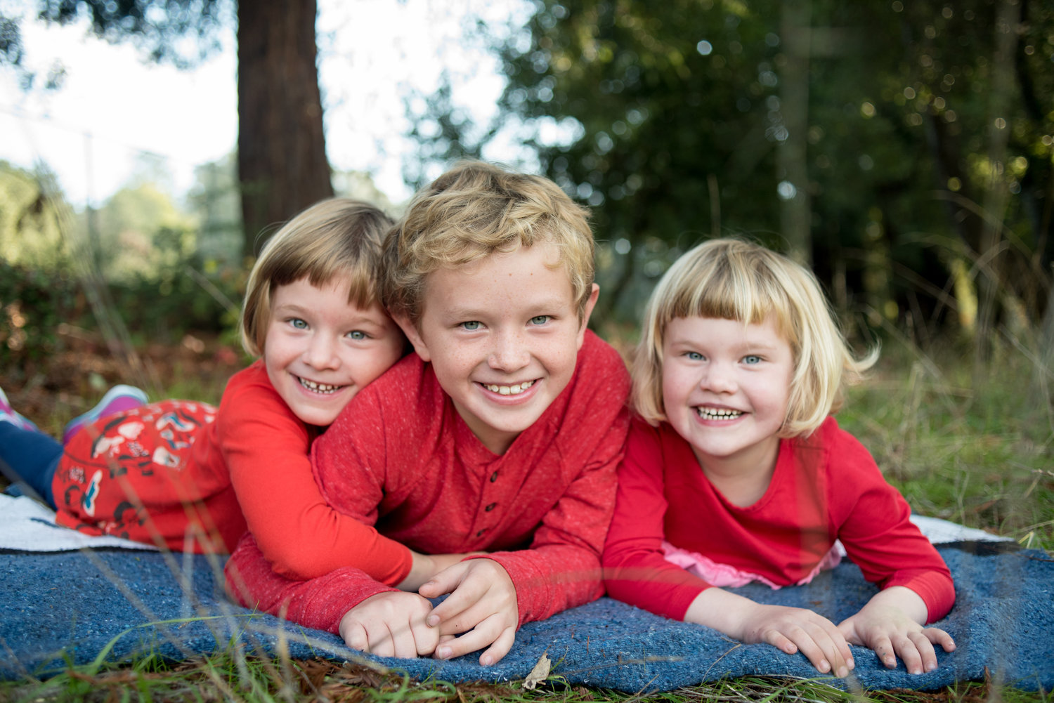 Three siblings laying down during holiday photo session